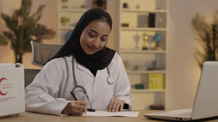 طبيبة سعودية تكتب وتعمل على المحمول في المكتب