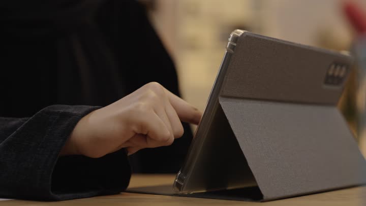 امرأة سعودية تستخدم جهاز لوحي في العمل