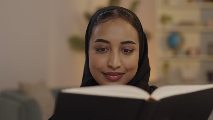 Arab Woman Reading Book in Home Library