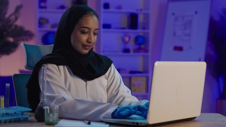 Saudi Female Scientist Working on Laptop in Lab