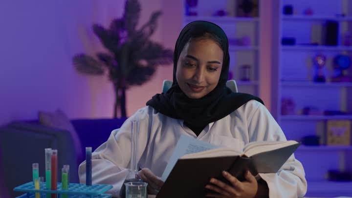عالمة عربية تقرأ كتاباً في المختبر الطبي