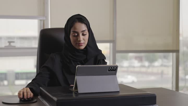 امرأة عربية خليجية سعودية محجبة ترتدي الزي الرسمي الكلاسيك تعمل فى شركة , استخدام فأرة الحاسوب للحصول على النتائج الدقيقة و الوصول السريع للمعلومات