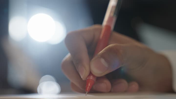 استخدام الورقة و الاقلام في تدوين الملاحظات المهمة , رجل عربي خليجي سعودي يمسك القلم الجاف و يسجل التعليمات , تصوير مقرب