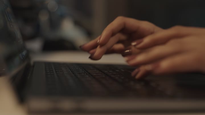 تصوير مقرب لامرأة عربية خليجية سعودية ترتدي العباءة السوداء تقوم بالكتابة على جهاز الحاسب المتنقل , دمج الاجهزة التقنية الحديثة في بيئة العمل للقيام بالاعمال بسهولة