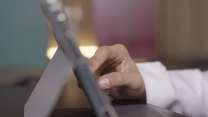 تقريب و تكبير الصور للنظر بدقة عالية الى الصور و الرسومات , رجل عربي خليجي سعودي يرتدي الثوب الابيض و الشماغ الملون يستخدم الجهاز اللوحي في العمل اليومي , تصوير مقرب