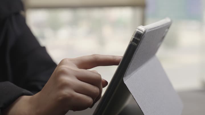 مراجعة الاعمال اليومية على الجهاز اللوحي , مفهوم توفير الوقت و الجهد باستخدام الاجهزة التقنية الحديثة , امرأة عربية خليجية سعودية محجبة ترتدي العباءة السوداء تلمس الشاشة الالكترونية , تصوير مقرب