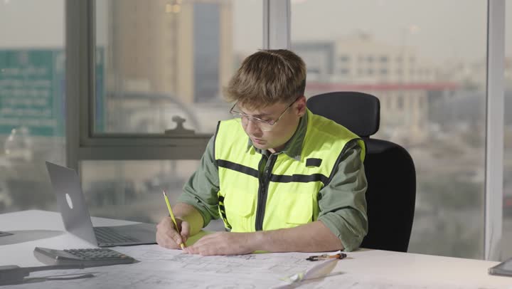 اجراء التعديلات الخاصة بالمشروع الهندسي , استخدام الاجهزة التقنية الحديثة في مجال الهندسة الممعمارية , مهندس اجنبي يرتدي الزي الكاجوال و السترة الواقية