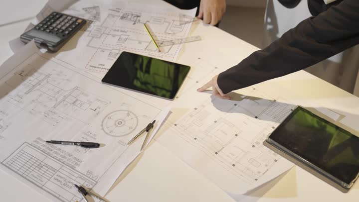 The Gulf Arab Saudi engineer is clarifying the important points in the plan, a Gulf Arab Saudi engineer wearing a white thobe is confirming the information presented, engineering tools on the desk, close-up shot.