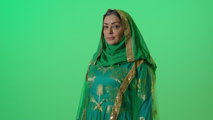 ارتداء زي المنطقة الوسطى في المناسبات الشعبية والوطنية, يوم بدينا 1727 م، ذكرى تأسيس الدولة السعودية الأولى 22 فبراير،  الاعتزاز بإنجازات الوطن، شعار الهوية الوطنية وراية الإسلام والتوحيد، بورتريه لامراه عربيه خليجيه سعوديه كبيرة بالسن ترتدي البرقع والشيلة  تنظر بايماءات السعادة والفخر ، كروما، خلفية خضراء