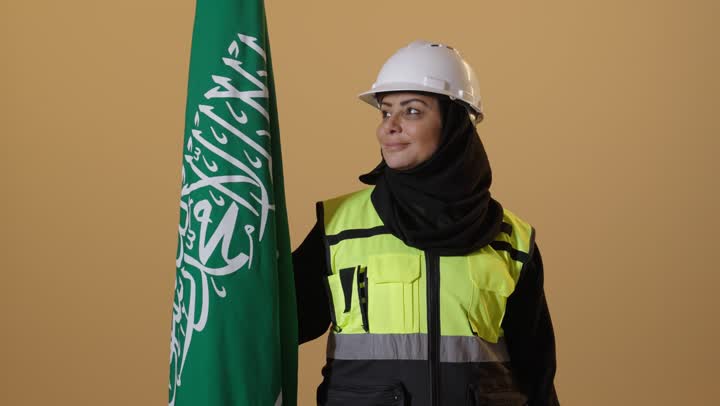 Celebrating the Saudi National Day with pride and dignity, the emblem of national identity and the banner of Islam and monotheism, commemorating the founding of the first Saudi state on February 22, a portrait of an elderly Saudi Gulf Arab engineer wearing a hijab, jacket, and safety helmet, with a beige background.