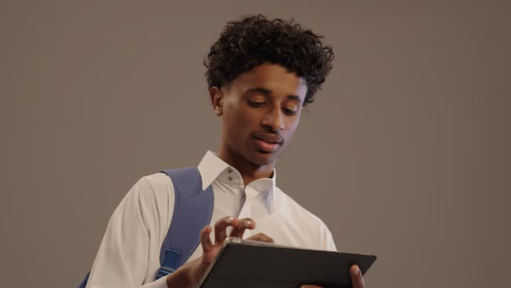 طالب سعودي بالثوب يستخدم جهازاً لوحياً في الاستوديو