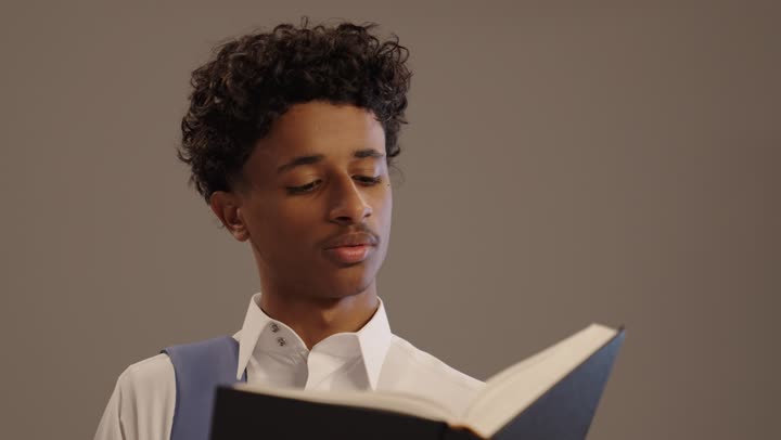 الاهتمام بتصفح الكتب المفيدة، الاستعداد للعام الدراسي الجديد، مراجعة الدروس اليومية, بورتريه لشاب عربي خليجي سعودي اسمر يرتدي الثوب التقليدي و حقيبة ظهر يقوم بقراءة كتاب, تطوير المناهج التعليمية في السعودية, خلفية بيج