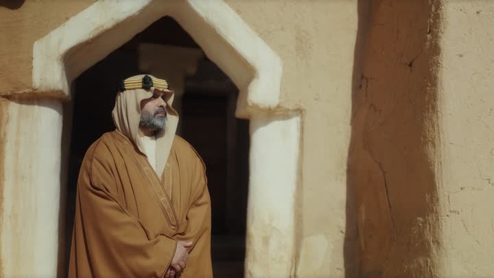 رجل  كبير السن عربي سعودي خليجي يرتدي البشت وعقال يوم التأسيس  يقف على شباك مبنى طيني شعبي قديم, ذكرى تأسيس الدوله السعوديه الاولى على يد  الامام محمد بن سعود, يوم بدينا 22 فبراير 1727م, الفخر بإنجازات الوطن, تحقيق الهويه الوطنيه