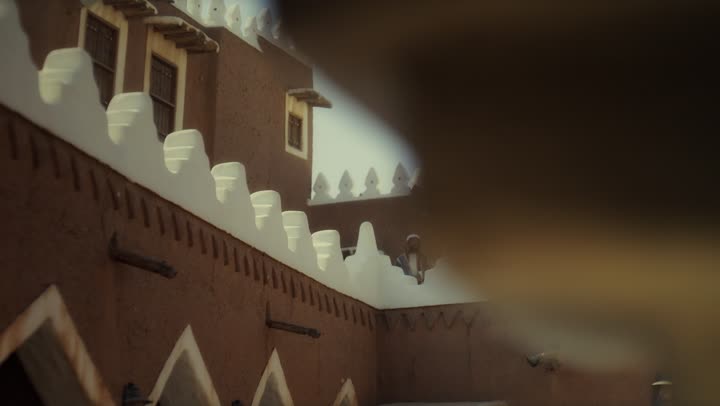 An elderly Saudi Arabian man, wearing a bisht and agal, stands in a traditional old mud-brick building on the anniversary of the founding of the first Saudi state by Imam Muhammad bin Saud, February 22, 1727. This day commemorates the nation's achievements and the realization of its national identity.