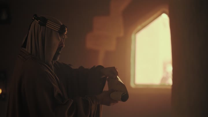 رجل  كبير السن عربي سعودي خليجي يرتدي البشت وعقال يوم التأسيس يفتح لفافه ورقيه قديمه, ذكرى تأسيس الدوله السعوديه الاولى على يد  الامام محمد بن سعود, يوم بدينا 22 فبراير 1727م, الفخر بإنجازات الوطن, تحقيق الهويه الوطنيه