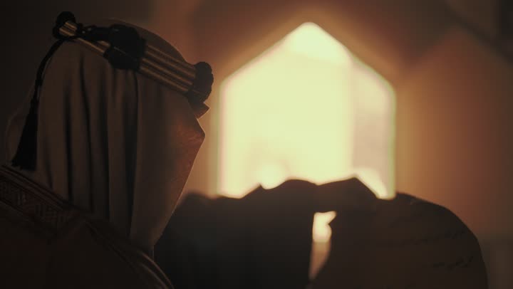 رجل  كبير السن عربي سعودي خليجي من الخلف يرتدي البشت وعقال يوم التأسيس يفتح لفافه ورقيه قديمه, ذكرى تأسيس الدوله السعوديه الاولى على يد  الامام محمد بن سعود, يوم بدينا 22 فبراير 1727م, الفخر بإنجازات الوطن, تحقيق الهويه الوطنيه