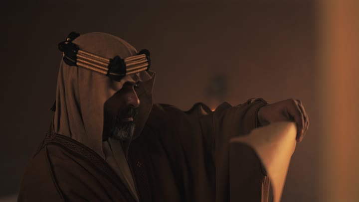 رجل  كبير السن عربي سعودي خليجي يرتدي البشت وعقال يوم التأسيس يفتح لفافه ورقيه قديمه, ذكرى تأسيس الدوله السعوديه الاولى على يد  الامام محمد بن سعود, يوم بدينا 22 فبراير 1727م, الفخر بإنجازات الوطن, تحقيق الهويه الوطنيه