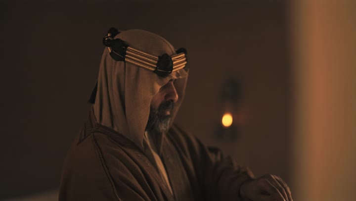 An elderly Saudi Arabian man, wearing a bisht and agal, opens an old paper roll on the anniversary of the founding of the first Saudi state by Imam Muhammad bin Saud, February 22, 1727 AD, a day of pride in the nation's achievements and the realization of national identity.