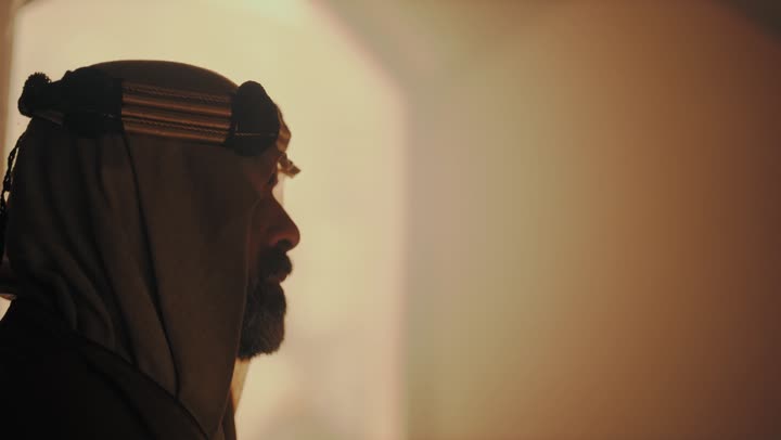 رجل  كبير السن عربي سعودي خليجي يرتدي البشت وعقال يوم التأسيس  يقف في مبنى طيني شعبي قديم, ذكرى تأسيس الدوله السعوديه الاولى على يد  الامام محمد بن سعود, يوم بدينا 22 فبراير 1727م, الفخر بإنجازات الوطن, تحقيق الهويه الوطنيه