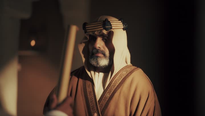 رجل  كبير السن عربي سعودي خليجي يرتدي البشت وعقال يوم التأسيس يستلم لفافه ورقيه قديمه, ذكرى تأسيس الدوله السعوديه الاولى على يد  الامام محمد بن سعود, يوم بدينا 22 فبراير 1727م, الفخر بإنجازات الوطن, تحقيق الهويه الوطنيه