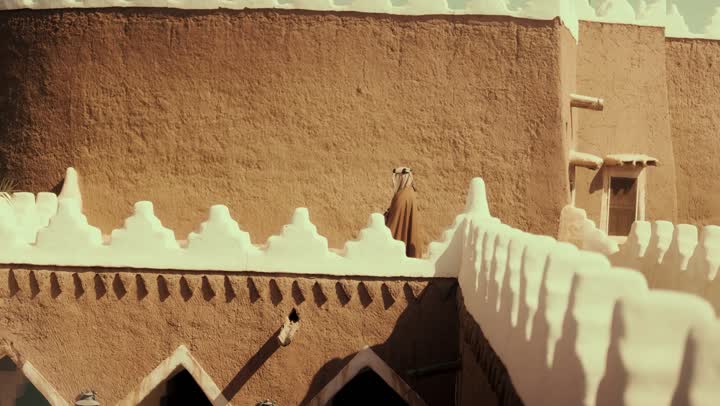 رجل كبير السن عربي سعودي خليجي يرتدي البشت وعقال يوم التأسيس يقف على مبنى طيني, ذكرى تأسيس الدوله السعوديه الاولى على يد الامام محمد بن سعود, يوم بدينا 22 فبراير 1727م, العمق التاريخي والحضاري للمملكة، مفهوم حب الوطن والانتماء اليه