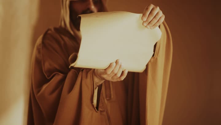 رجل كبير السن عربي سعودي خليجي يرتدي البشت وعقال يوم التأسيس يفتح لفافة ورقية داخل مبنى طيني, ذكرى تأسيس الدوله السعوديه الاولى على يد الامام محمد بن سعود, يوم بدينا 22 فبراير 1727م,  العمق التاريخي والحضاري للمملكة، ارتداء الأزياء التقليدية تعكس التراث