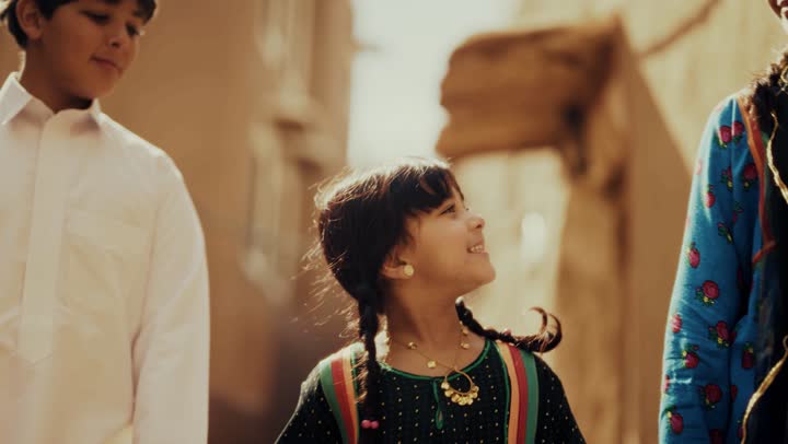 3 اخوه عربيين سعوديين خليجيين يرتدون زي شعبي تراثي يوم التأسيس يسيروا في حي طيني مع مسك الايدي, ذكرى تأسيس الدوله السعوديه الاولى على يد الامام محمد بن سعود, يوم بدينا 22 فبراير 1727م,  العمق التاريخي والحضاري للمملكة، مفهوم حب الوطن والانتماء اليه