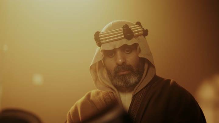 رجل كبير السن عربي سعودي خليجي يرتدي البشت وعقال يوم التأسيس يتصفح قصص تاريخية قديمة, ذكرى تأسيس الدوله السعوديه الاولى على يد الامام محمد بن سعود, يوم بدينا 22 فبراير 1727م,  العمق التاريخي والحضاري للمملكة، ارتداء الأزياء التقليدية تعكس التراث