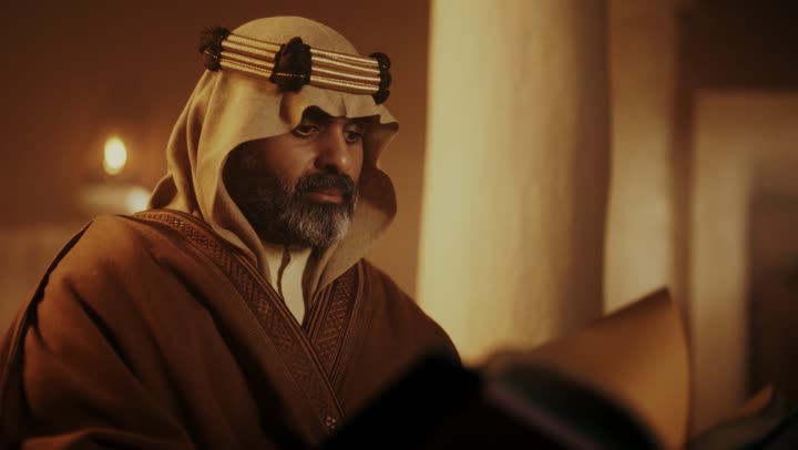 رجل كبير السن عربي سعودي خليجي يرتدي البشت وعقال يوم التأسيس يتصفح قصص تاريخية قديمة, ذكرى تأسيس الدوله السعوديه الاولى على يد الامام محمد بن سعود, يوم بدينا 22 فبراير 1727م,  العمق التاريخي والحضاري للمملكة، ارتداء الأزياء التقليدية تعكس التراث