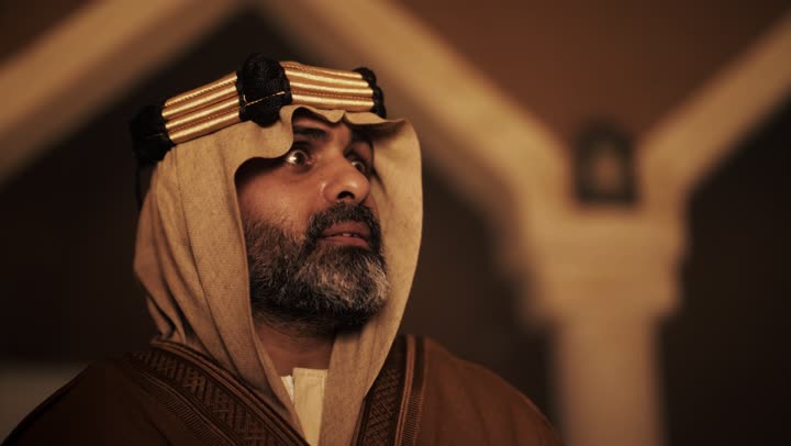 An elderly Arab Saudi Gulf man wearing a bisht and agal on Foundation Day contemplates the details of a mud building, commemorating the establishment of the first Saudi state by Imam Muhammad bin Saud, on the day we began, February 22, 1727. Wearing traditional attire reflects the heritage, historical depth, and civilization of the Kingdom.