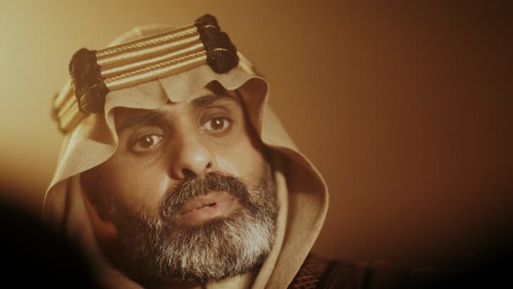 رجل كبير السن عربي سعودي خليجي يرتدي البشت وعقال يوم التأسيس يتمتم بقراءة تاريخ البلد, ذكرى تأسيس الدوله السعوديه الاولى على يد الامام محمد بن سعود, يوم بدينا 22 فبراير 1727م, ارتداء الأزياء التقليدية تعكس التراث, العمق التاريخي والحضاري للمملكة