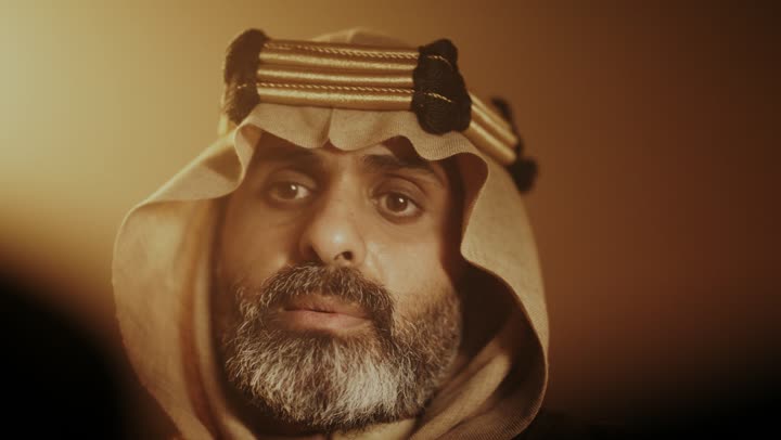 رجل كبير السن عربي سعودي خليجي يرتدي البشت وعقال يوم التأسيس يتمتم بقراءة تاريخ البلد, ذكرى تأسيس الدوله السعوديه الاولى على يد الامام محمد بن سعود, يوم بدينا 22 فبراير 1727م, ارتداء الأزياء التقليدية تعكس التراث, العمق التاريخي والحضاري للمملكة