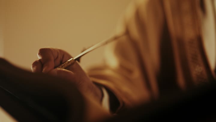 رجل كبير السن عربي سعودي خليجي يرتدي البشت وعقال يوم التأسيس يكتب رسالة على لفافة ورقية قديمة, ذكرى تأسيس الدوله السعوديه الاولى على يد الامام محمد بن سعود, يوم بدينا 22 فبراير 1727م, ارتداء الأزياء التقليدية تعكس التراث, العمق التاريخي والحضاري للمملكة