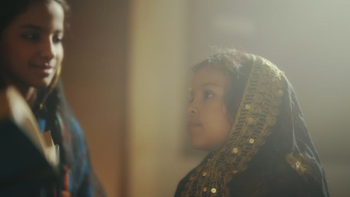 Two Saudi Arabian Gulf girls are wearing traditional attire during national holidays, the love among family members, telling a story to the children, sitting in one of the traditional clay houses, the day we started in 1727 AD, the anniversary of the founding of the first Saudi state on February 22.