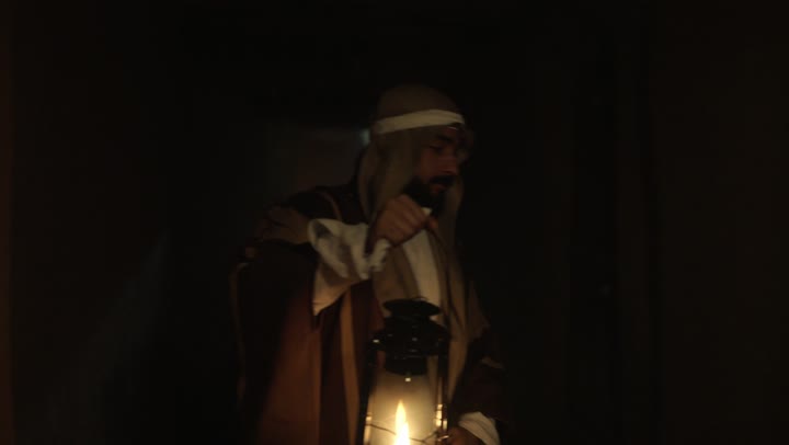 The anniversary of the establishment of the first Saudi state is on February 22, showing love and loyalty to the state and the homeland. An Arab Gulf Saudi man wearing traditional folk attire holds a lit lantern in his hand, a source of pride and honor for the national identity. It is the day we began in 1727 AD, a national holiday and occasion, with a popular neighborhood and traditional clay houses.