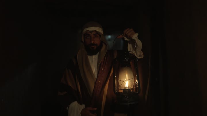 The day we started was 1727 AD, a popular neighborhood with traditional clay houses, a holiday and a national occasion, the anniversary of the founding of the first Saudi state on February 22, expressing love and loyalty to the state and the homeland, an Arab Gulf Saudi man wearing traditional folk attire holding a lit lantern in his hand, pride and honor in national identity.