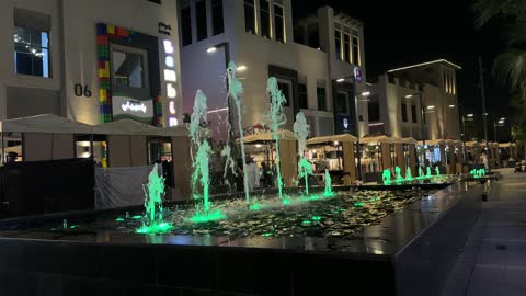 نوافير مياه خضراء مضيئة في سوق ليلي سعودي