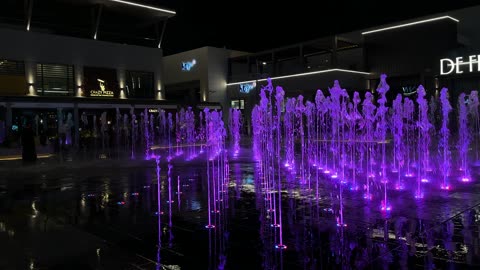 فيديو نافورة مضيئة باللون الأرجواني في ساحة ليلية