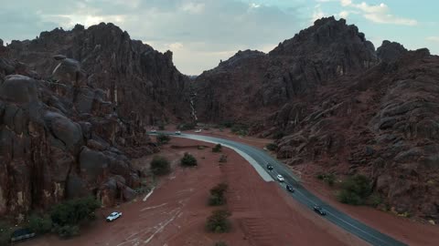 سيارات تسير في طريق وادي صحراوي تصوير جوي