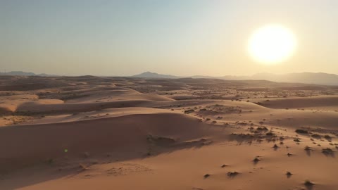 تصوير جوي للكثبان الرملية في الصحراء وقت الغروب