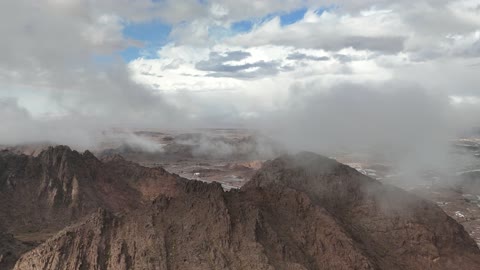 Aerial Drone View of Clouds Moving Over Mountain Peaks