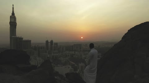 Saudi Man Overlooking Mecca Clock Tower at Sunset
