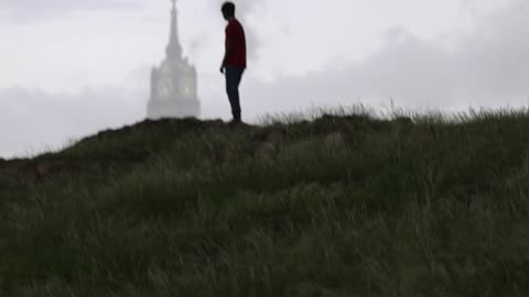 رجل على تلة مع خلفية برج الساعة مكة