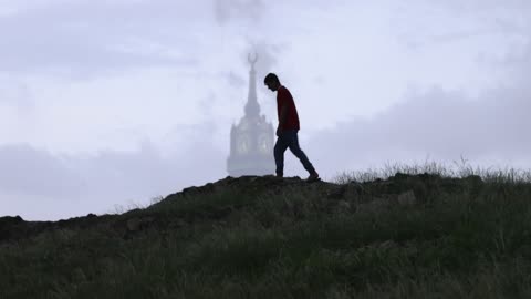 رجل يمشي بالقرب من برج الساعة بمكة المكرمة