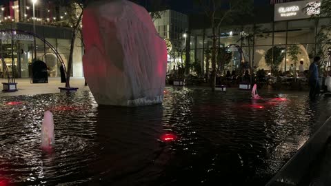 City Walk Fountain with a rock sculpture and night lighting in the city of Khobar, Saudi Arabia.