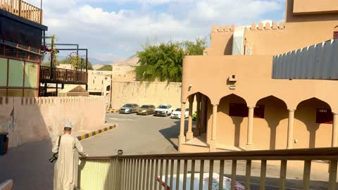 رجل يمشي في قرية تراثية عمانية على الدرج