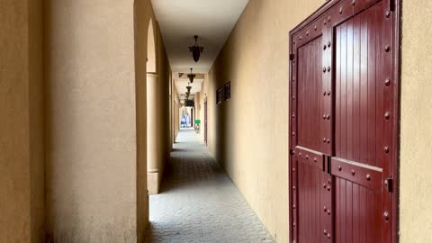 ممر مبنى عربي تقليدي مع أبواب حمراء بعمان