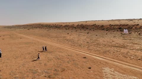 Group of People Walking in Desert Aerial Drone Footage