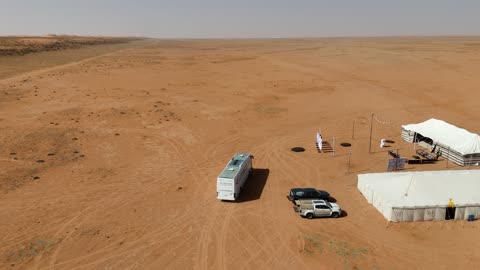 Desert Campsite Aerial Drone Footage with Bus and Tents