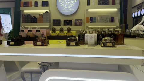 عرض متجر عطور مع رجل عربي خلف المنصة
